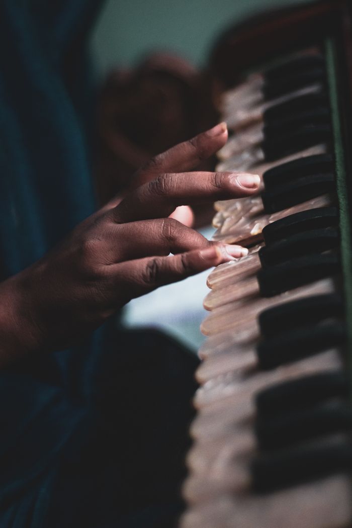 Intimate shot of a musician gracefully playing a piano, focusing on skilled hand movements.